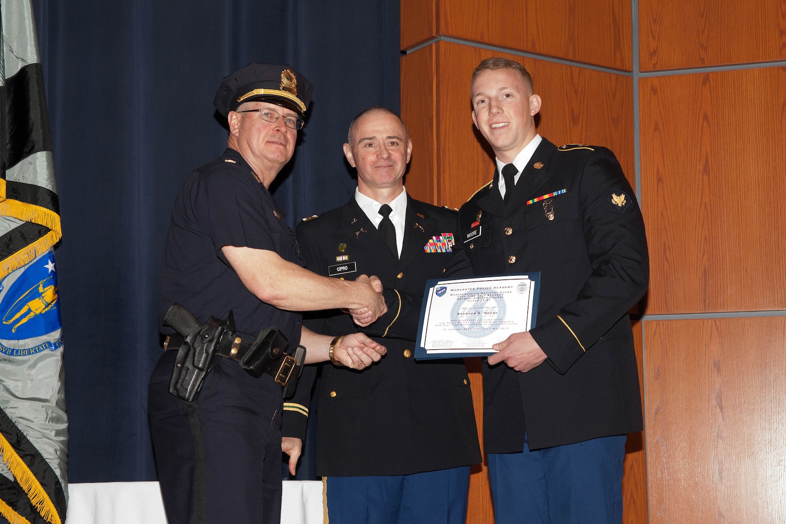 Army Maj. Richard Cipro, deputy provost marshal, Massachusetts National Guard and Worcester Police Sergeant, center, with Capt. Jack Ryder, Worcester Police Academy director (and Spc. Brandon Moore, Massachusetts Army National Guard graduate of the police academy. Continuing its long tradition of leadership and innovation, the Massachusetts National Guard in conjunction with the Worcester Police department graduated the nation’s first full-time civilian police academy for Army Military Police and Air Force Security Forces with a ceremony, here, May 1, 2015.