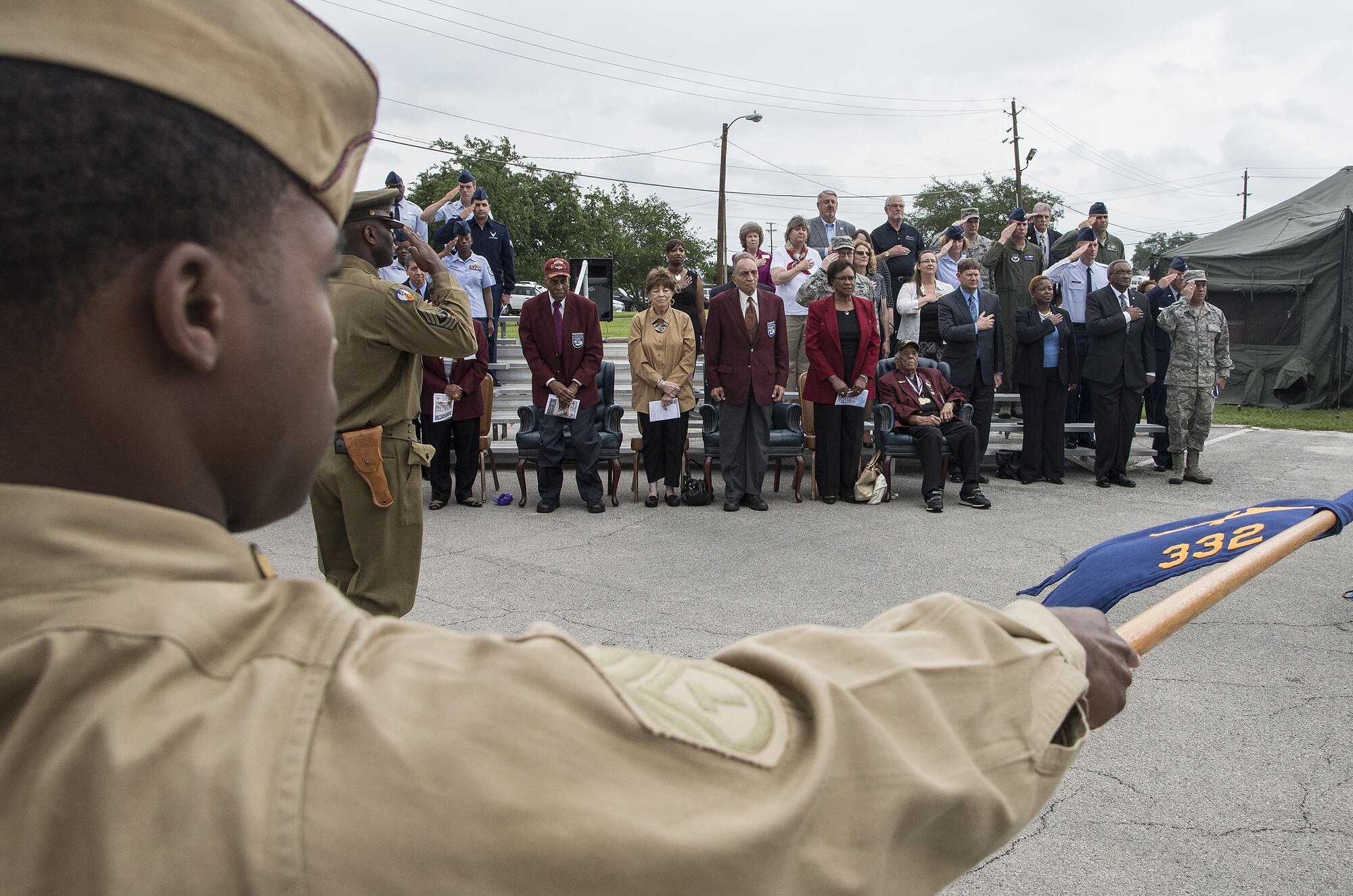 Chief Master Sgt. Richard West, U.S. Air Force Airman Heritage Museum & Enlisted Character Development Center director, leads a flight of Joint Base San Antonio Airmen on a performance tribute while wearing historic military uniforms during an unveiling ceremony for the Enlisted Tuskegee Airman Exhibit May 4, 2015, at Joint Base San Antonio-Lackland’s U.S. Air Force Airman Heritage Museum & Enlisted Character Development Center. The unveiling ceremony honors the Tuskegee Airmen, a group of African-American military ground support Airmen who were part of the 332nd Fighter Group and the 477th Bombardment Group during World War II. The exhibit, a three-dimensional recreation of a World War II combat operations room displaying an enlisted aircraft line mechanic, enlisted administrator and a Tuskegee fighter pilot, depicts the hard work, sacrifice and determination the Tuskegee Airmen put forth as members of the Army Air Corps to help America win World War II. (U.S. Air Force photo by Johnny Saldivar)