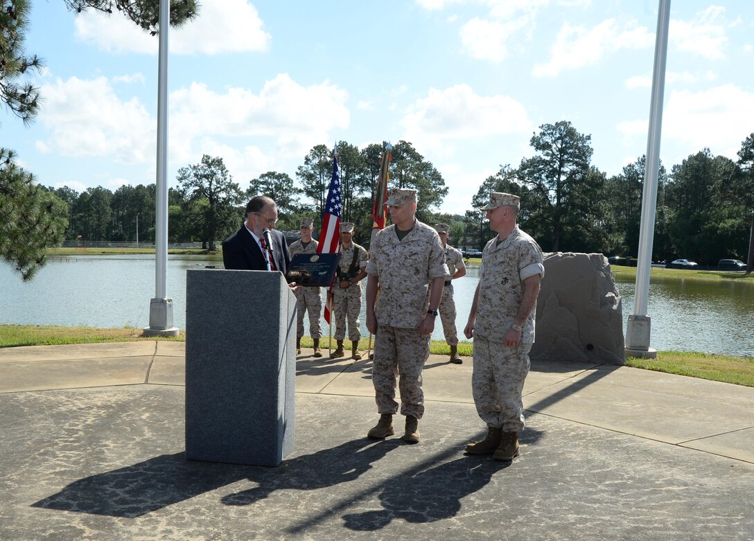 Robert Vazzi, area director for the Occupational Safety and Health Administration, Savannah, Ga., area office, presents a plaque recognizing Marine Corps Logistics Base Albany as a Voluntary Program Star Site. 