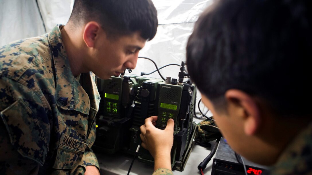 Cpl. Juan Ramirez, fire support man and Cpl. Guillermo Mendoza, a joint fires observer, both with 1st Air Naval Gunfire Liaison Company, test multiple radios during Exercise Maple Resolve 15 aboard Canadian Maneuver Training Center Camp Wainwright, Alberta, April 30, 2015. Maple Resolve allowed the Marines to gain a better understanding of the Rapid Response Kit increasing interoperability with foreign military elements.(U.S. Marine Corps photo by Cpl. Owen Kimbrel)