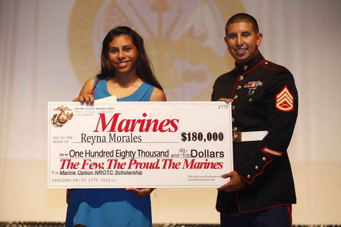 SSgt Mario Sanchez from RSS Fort Myers presents a display check for $180,000
to Ms. Reyna Morales of East Lee High School. Against competitive
competition from her peers around south Florida, Ms. Morales received and
accepted the Marine Option Naval Reserve Officers Training Corps'
scholarship. (Photo by Sgt Michael Lopez)
