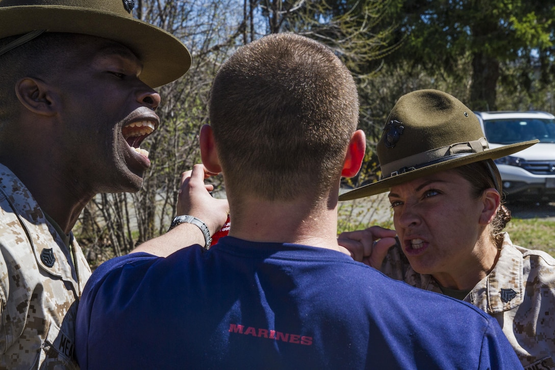 Staff Sgt. Gerren Means and Sgt. Megan Roberts suggest that a poolee "pick up his volume" during Recruiting Station Portsmouth's all-hands pool function, May 2. The function was a two-day evolution where nearly 400 poolees throughout Maine, New Hampshire and eastern Massachusetts went through screenings and physical tests with added motivation from two Parris Island drill instructors. Means is a senior drill instructor with India Co., 3rd Recruit Training Battalion, and Roberts is a drill instructor with Oscar Co., 4th RTB.