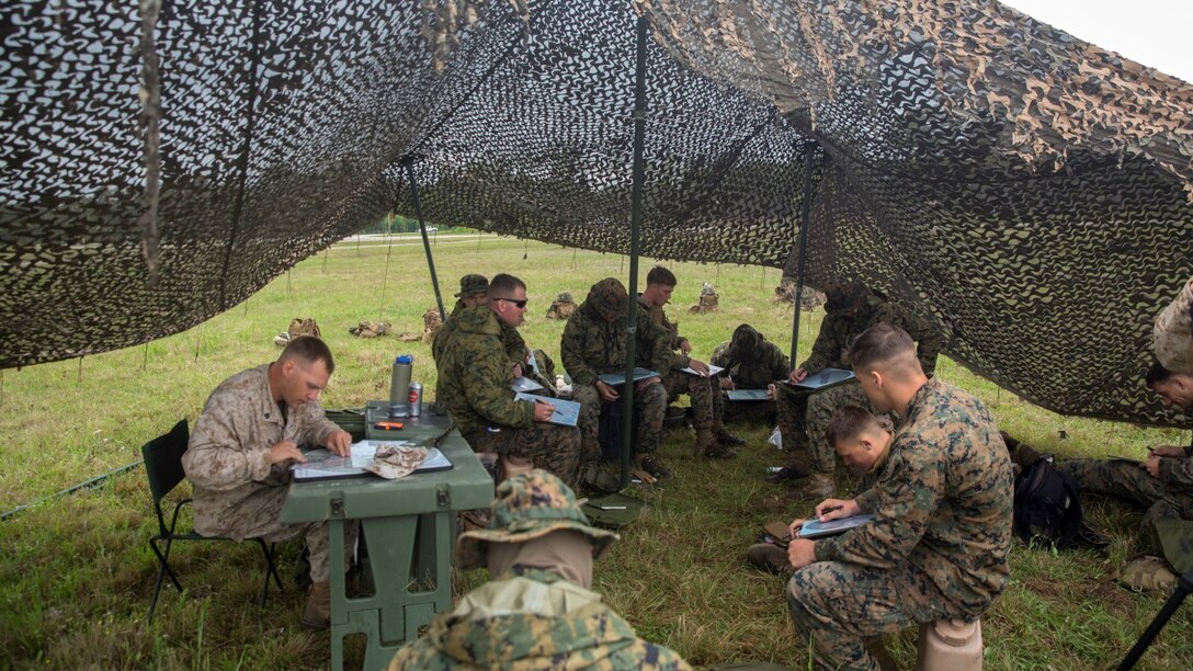 Marines from 2nd Marine Division calculate the information received by the forward observers during the Advanced Machine Gunners Course at range G-3 aboard Camp Lejeune, N.C., April 30, 2015. In order to learn a new engagement method previously only employed by mortarmen, the Marines shot the MK-19 grenade launcher from behind a berm at targets that were not visible to them so that they could fire at the enemy without being in harm’s way. (U.S. Marine Corps Photo by Lance Cpl. Aaron Fiala/Released)