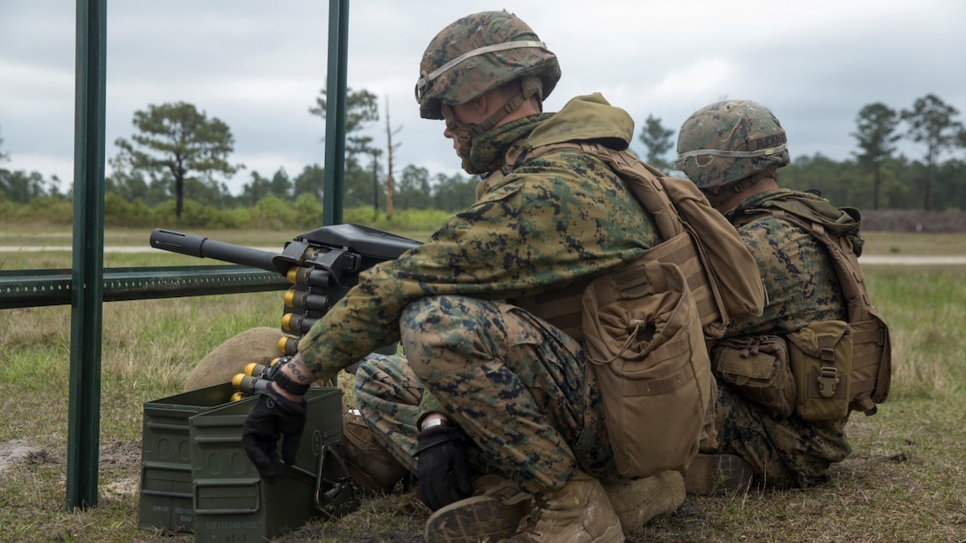Two Marines from 2nd Marine Division engage targets from behind a berm with the MK-19 grenade launcher during the Advanced Machines Gunners Course at range G-3 aboard Camp Lejeune, N.C., April 30, 2015. In order to learn a new engagement method previously only employed by mortarmen, the Marines shot the MK-19 grenade launcher from behind a berm at targets that were not visible to them so that they could fire at the enemy without being in harm’s way. (U.S. Marine Corps Photo by Lance Cpl. Aaron Fiala/Released)