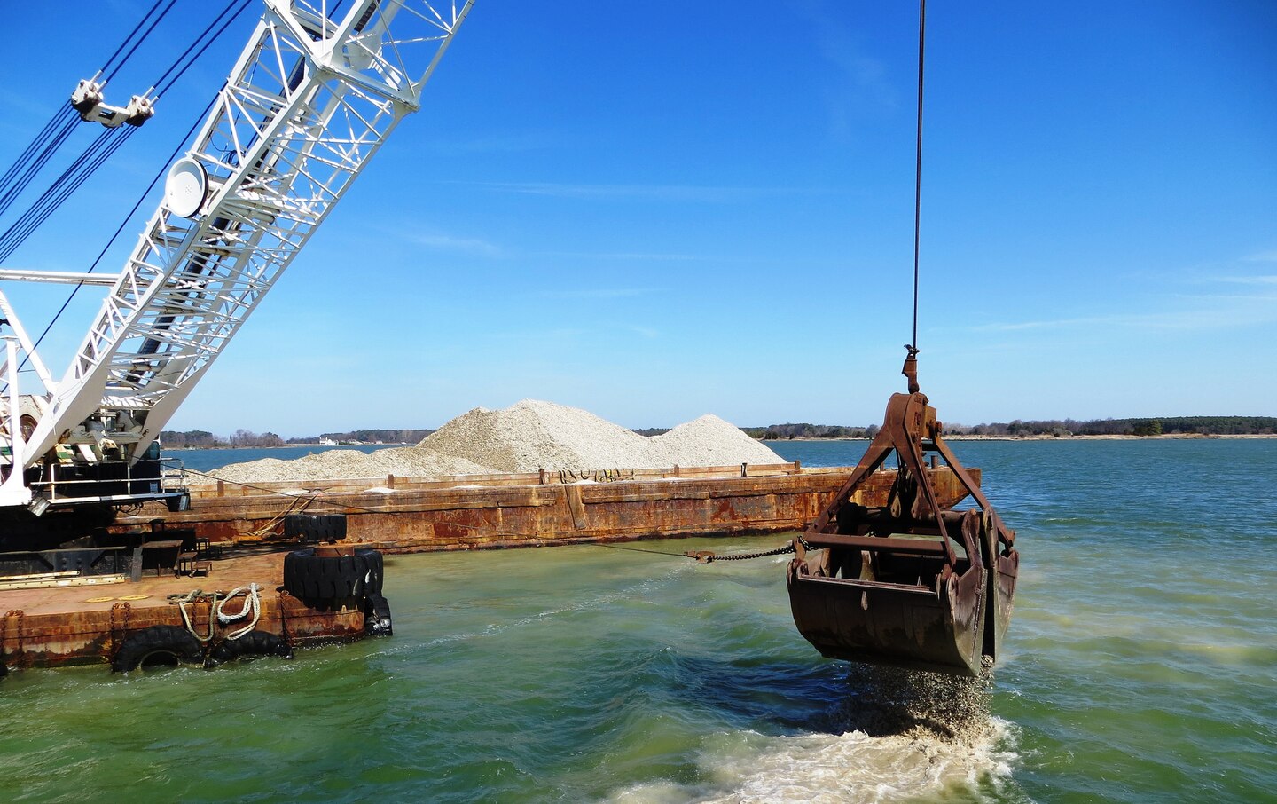 The U.S. Army Corps of Engineers, Baltimore District, places shell to restore oyster reefs in the Chesapeake Bay tributary of Harris Creek, April 1, 2015. The shell comes from processing plants in the mid-Atlantic region and is permitted to be imported and placed in the river. There is not sufficient natural shell available to restore oyster habitat in the Bay. Therefore, artificial reefs, known as substrate or alternative substrate, have been constructed at restoration locations throughout the Bay. Substrate may be any combination of oyster shell, clam shell, or alternative substrate such as crushed concrete, rock or granite.The shell is 2 to 3 inches in diameter. (U.S. Army Photo by Sean Fritzges)