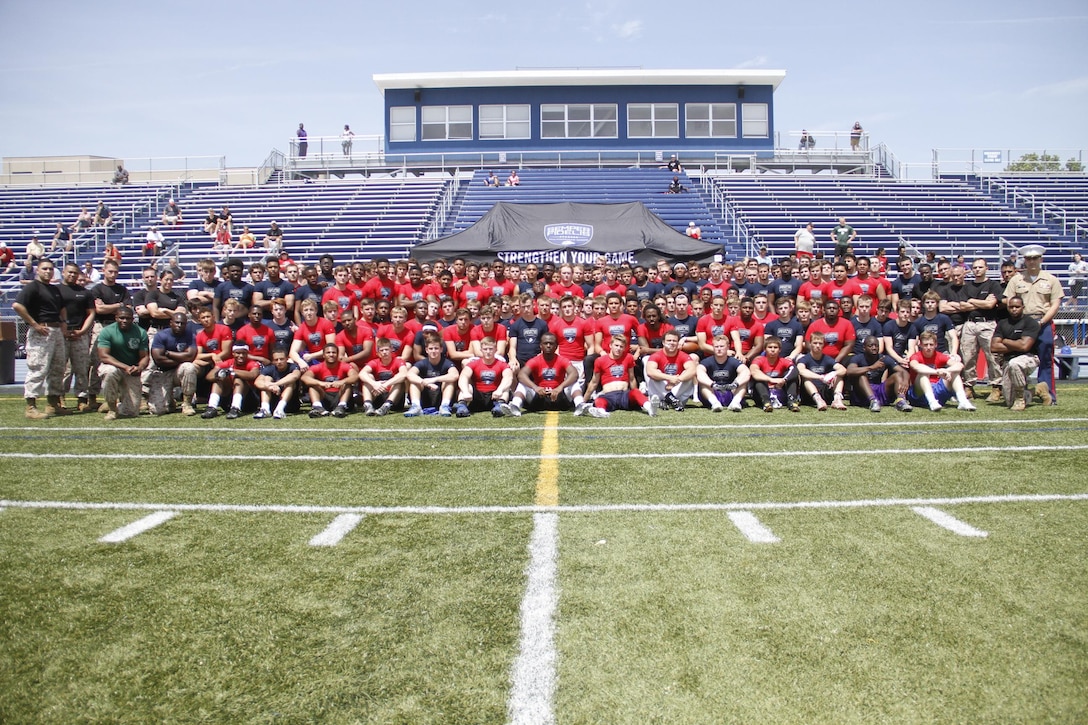 Marines from Marine Corps Recruiting Station Kansas City and football players from across the region, pose for a photo at the conclusion of RS Kansas City's Semper Fidelis All-American Football Camp at Rockhurst High School's Vincent P. Dasta Memorial Football Stadium May 3, 2015. 