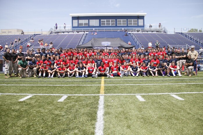 Marines from Marine Corps Recruiting Station Kansas City and football players from across the region, pose for a photo at the conclusion of RS Kansas City's Semper Fidelis All-American Football Camp at Rockhurst High School's Vincent P. Dasta Memorial Football Stadium May 3, 2015. 