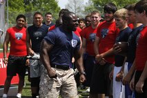 Gunnery Sergeant Aubrey L. McDade, Jr., a Company I, 3rd Battalion, Recruit Training Regiment, Marine Corps Recruit Depot San Diego chief drill instructor, motivates football players during the Semper Fidelis All-American Football Camp at Rockhurst High School's Vincent P. Dasta Memorial Football Stadium May 3, 2015. 