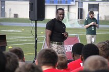 Sergeant Laronald McKinney, a Marine Corps Recruiting Station Kansas City recruiter, talks with football players during the Semper Fidelis All-American Football Camp at Rockhurst High School's Vincent P. Dasta Memorial Stadium May 3, 2015. McKinney, a former high school player himself, talked with the players of how the principles he learned on the football field related to those within the Marine Corps. 