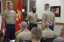 Sergeant Major Johnnie Hughes, outgoing Marine Corps Recruiting Station Kansas City sergeant major, prepares to relinquish the sword of office to Maj. Alfred L. Butler IV, RS Kansas City commanding officer, who will then pass the sword to Sgt. Maj. Christopher A. Farrell, oncoming RS Kansas City sergeant major during RS Kansas City's sergeant major relief and appointment at the Kansas City Military Entrance Processing Station April 17, 2015. 