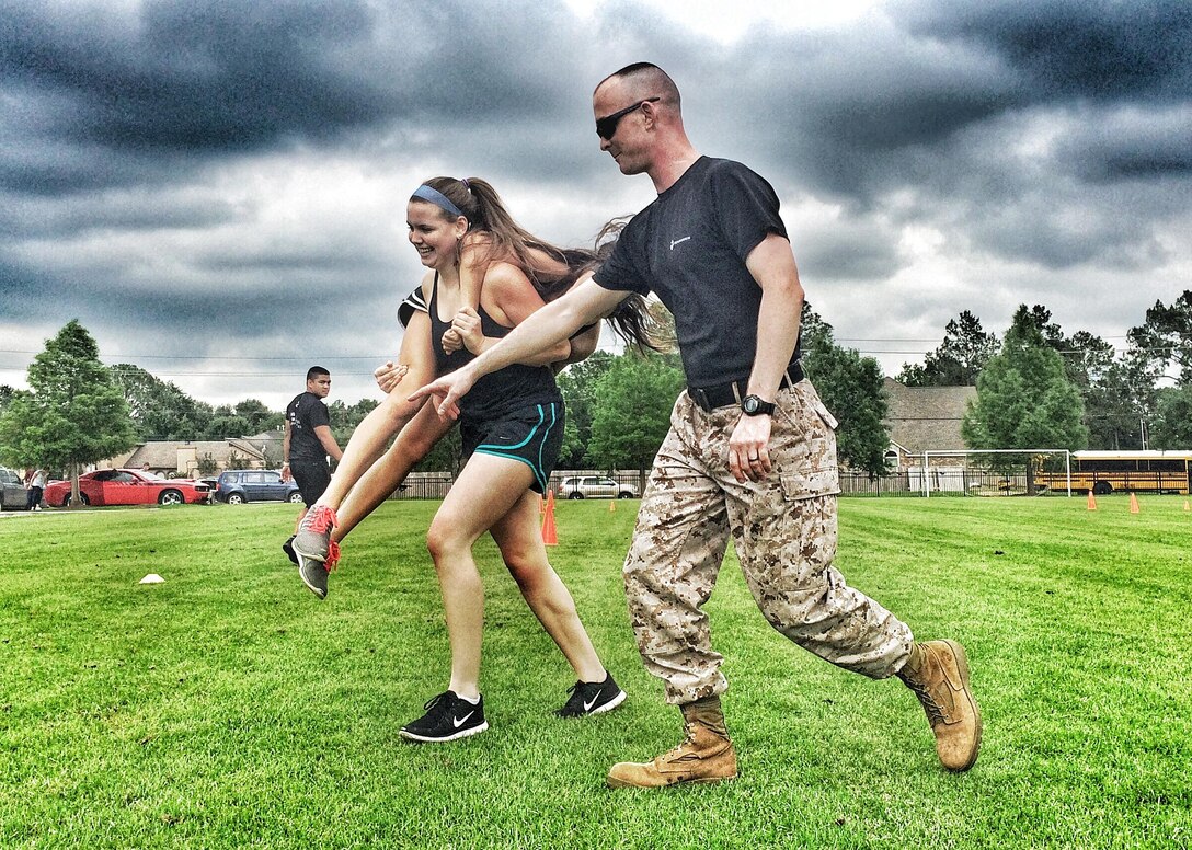 Sergeant Christopher Miller, a canvassing recruiter with Sub-Station Baybrook, 
Recruiting Station Houston, leads a female Combat Fitness Test challenge with 
members of the female athletic teams of Friendswood High School in Houston, 
Tx., May 06, 2015.  Ladies with the basketball, volleyball, and track team 
came out and dominated the Marine Corps Combat Fitness Challenge.
(US Marine Corps photo by Sgt. Gabby Bustos)
