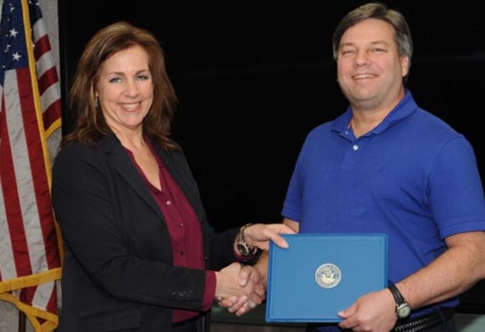 150324-N-DE005-001 DAHLGREN, Va Melissa Lederer, Naval Surface Warfare Center Dahlgren Division (NSWCDD) Systems Safety Engineering Division head, presents an award certificate to Greg Buchanan, an NSWCDD System Safety and Systems Engineer, at a ceremony honoring the command's inventors here March 24. 
