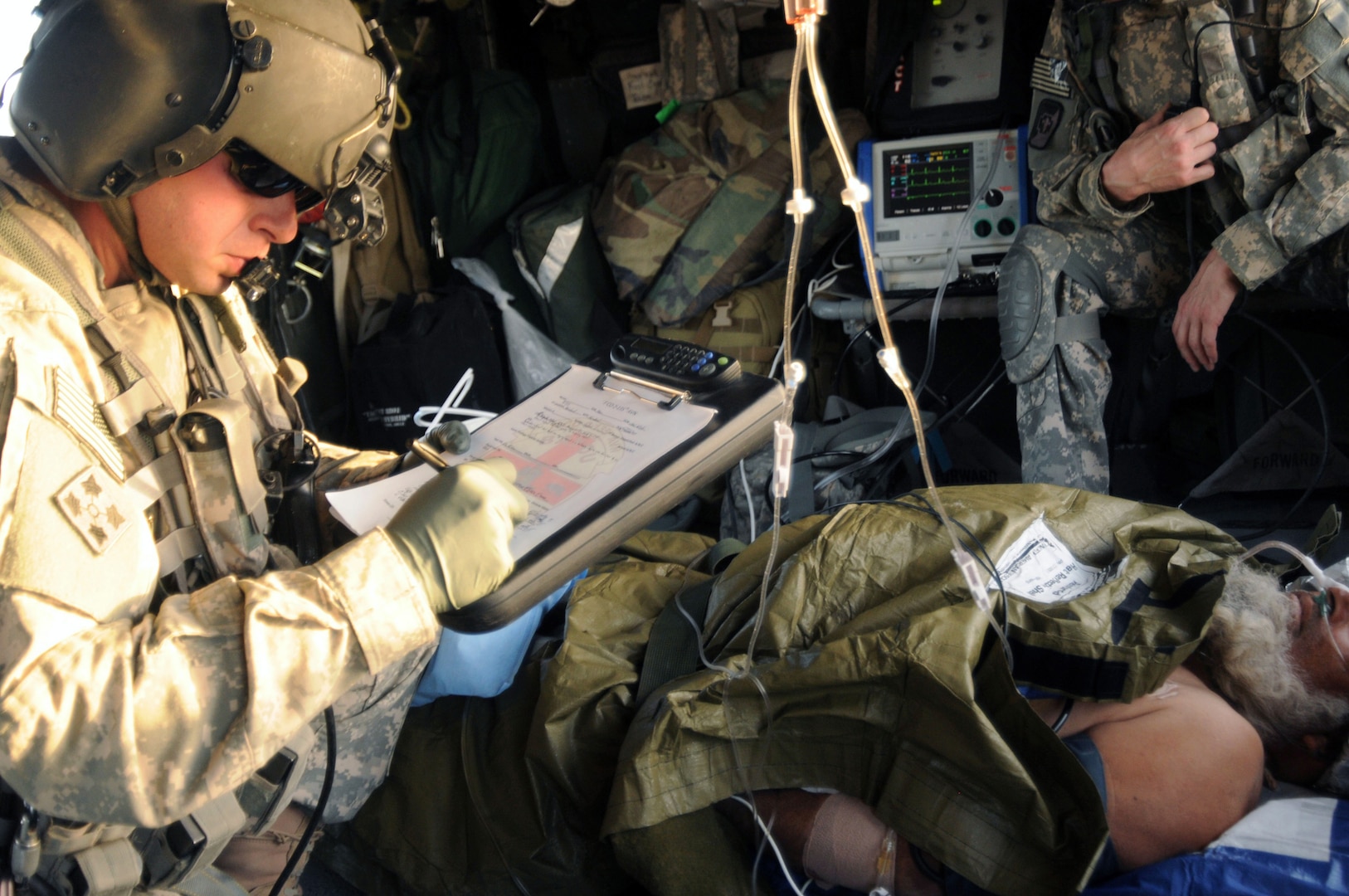 Sgt. 1st Class David Jacob, senior flight medic for the Louisiana National Guard writes information about a patient that is being transported an Afghan Army soldier. The soldiers of F Company fly into hostile fire areas to pick up and transport patients to safety, and are able to perform many different procedures while in the air.