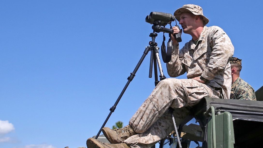 Sergeant Charles Holloway, the chief scout with Scout Sniper Platoon, Weapons Company, 2nd Battalion, 2nd Marine Regiment looks through his high-powered optics to locate a scout sniper candidate during a stalking exercise in the vicinity of SR-10 aboard Marine Corps Base Camp Lejeune, North Carolina, April 22, 2015. The stalking exercise taught Marines the importance of going undetected during movement and while firing at a target. The stalking exercise was one of many conducted by Marines attending the Scout Sniper Basic Preparation Course over the course of two weeks during the month of April.