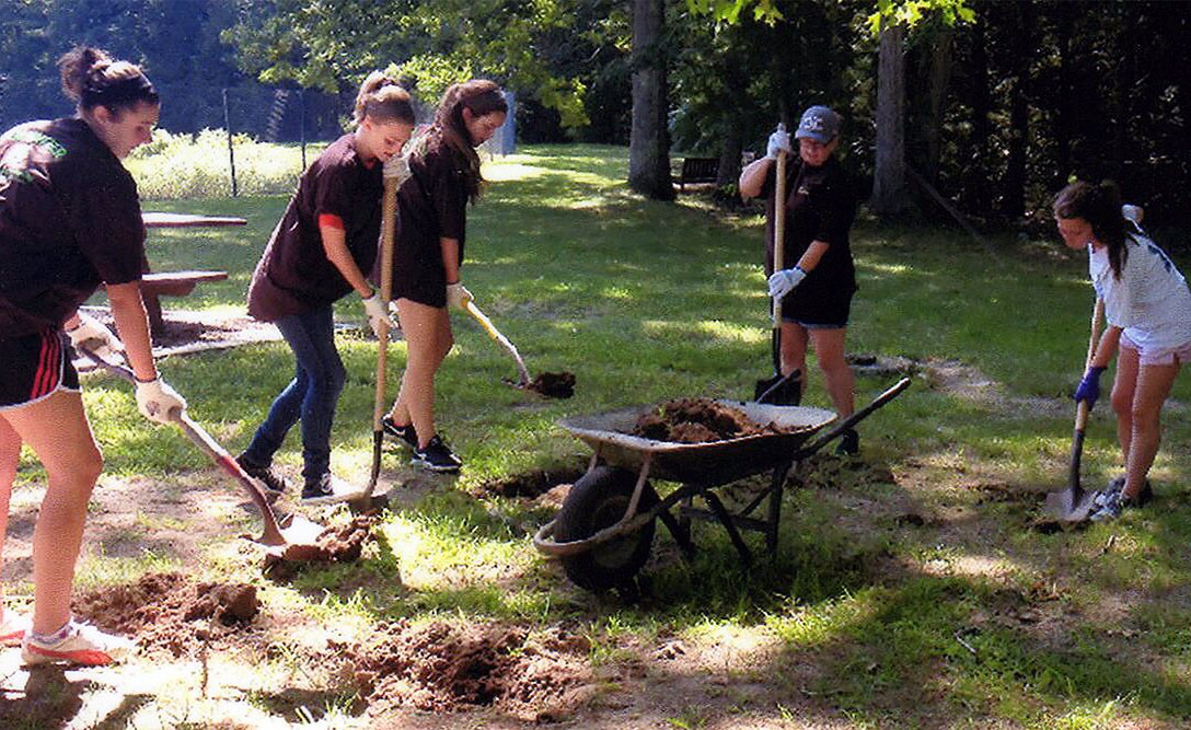 Girl Scout Rachel Cronin (far right) and her team prepare the ground at West Hill Dam for her Teeter-Totter Project that would earn her the Gold Award. 