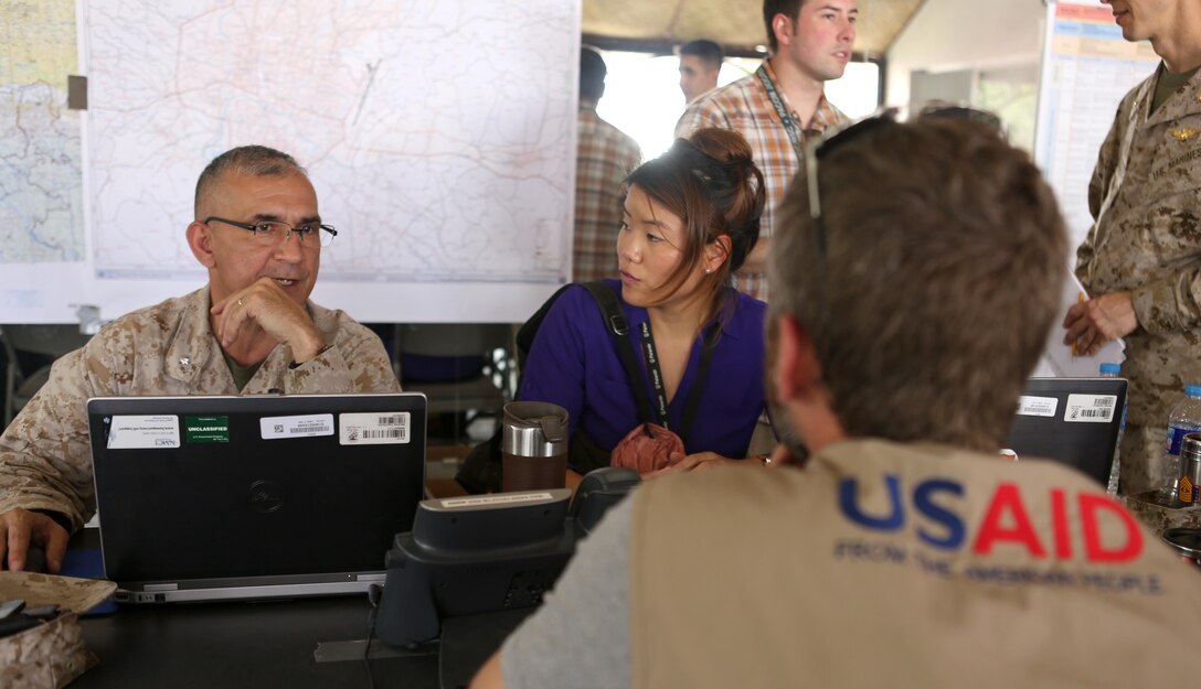 (From left to right) U.S. Marine Corps Lt. Col. Rod Legowski, Army Capt. Linda Cho and Scott Aronson USAID conduct a meeting in the Joint Task Force (JTF) 505, Joint Operations Command Center (FWD) on May 6, 2015. The Nepalese Government requested the U.S. Government’s assistance after a 7.8 magnitude earthquake struck the country, April 25, 2015. U.S. Marines from III Marine Expeditionary Force have come together with other U.S. services to form JTF-505. JTF-505 works in conjunction with USAID and the international community to provide unique capabilities to assist Nepal.