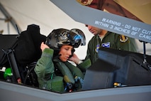 Lt. Col. Christine Mau, 33rd Operations Group deputy commander, puts on her helmet before taking her first flight in the F-35A on Eglin Air Force Base, Florida, May 5, 2015. Mau, who previously flew F-15E Strike Eagles, made history as the first female F-35 pilot in the program. (U.S. Air Force photo/Staff Sgt. Marleah Robertson)