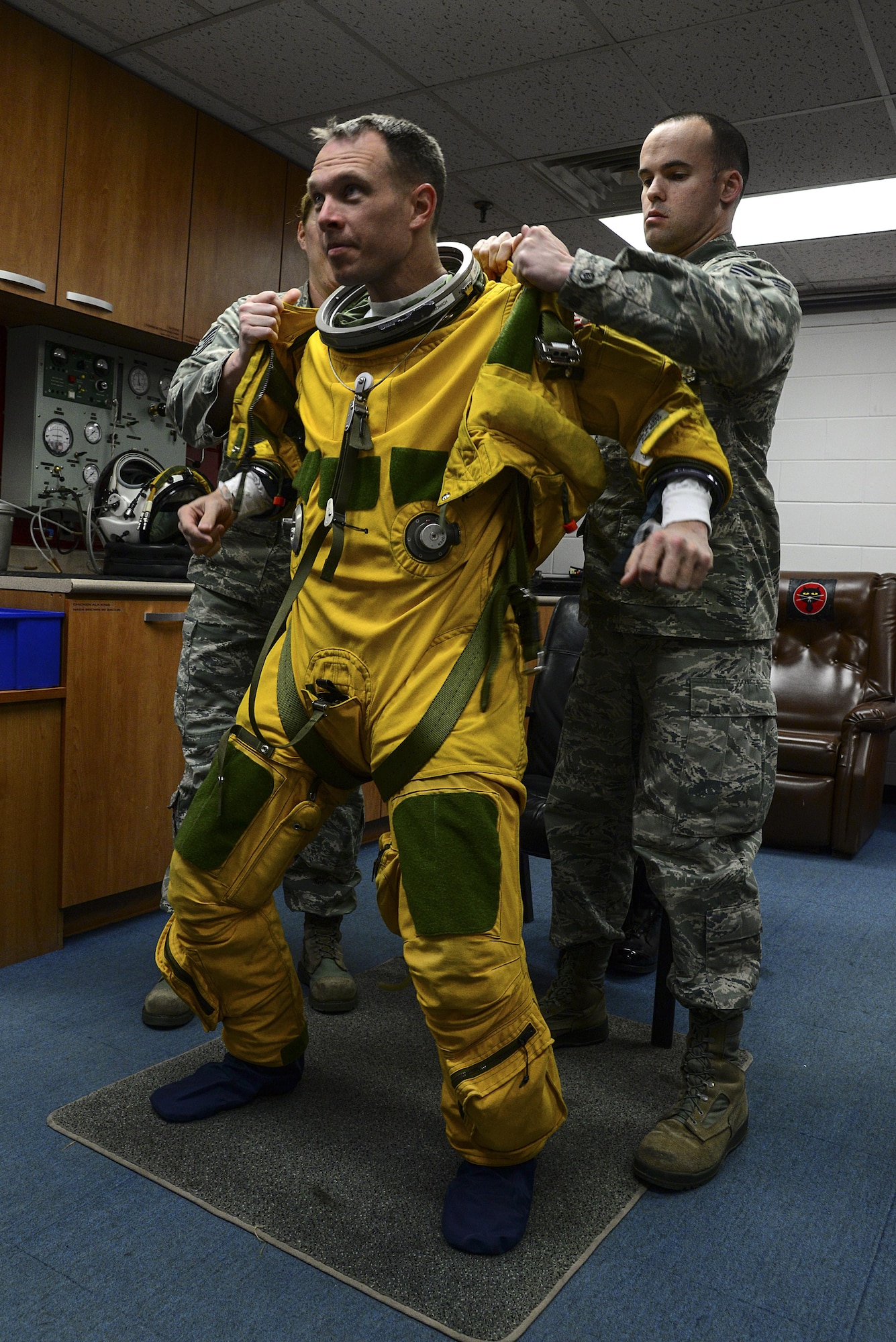Staff Sgts. Stacy Klein and Staff Sgt. Joseph Kennedy, 5th Reconnaissance Squadron physiological technicians, assist Lt. Col. Luke Lokowich, the 5th RS commander and a U-2 pilot, with his high-altitude pressure suit April 22, 2015, at Osan Air Base, South Korea. A pressure suit is a protective suit worn by pilots who may fly at altitudes where the air pressure is too low for an unprotected person to survive. (U.S. Air Force photo/Senior Airman Matthew Lancaster)