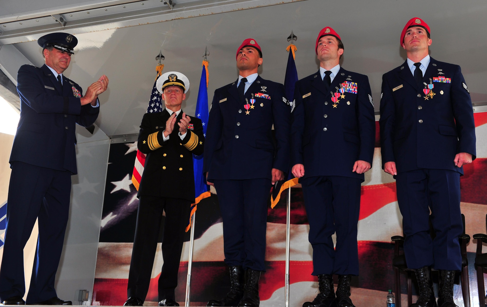 U.S. Air Force Lt Gen Bradley A. Heithold, commander of Air Force Special Operations Command, and U.S. Navy Vice Admiral Sean A. Pybus, deputy commander of Special Operations Command, applaud three U.S. Air Force Special Tactics combat controllers, who received an Air Force Cross and two Silver Stars today. They are credited with saving the lives of more than 80 U.S. Army Special Forces and Afghan Commando teammates by providing flawless air-to-ground integration in the special operations battlefield. (U.S. Air Force photo by Airman First Class Ryan Conroy/Released)