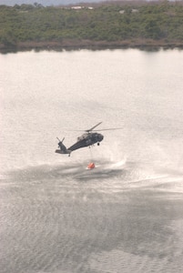 New York Army National Guard aircrews fill their water bucket from a local state park lake to assist in fighting a forest fire in Shawangunk Ridge State Forest near Summitville in Ulster County May 5. Two UH-60 Black Hawk helicopters and crew members based at the Army Aviation Support Facility at Albany International Airport in Latham joined two additional New York State Police helicopters to drop water along the fire line to help contain the wildfire that began May 3. 