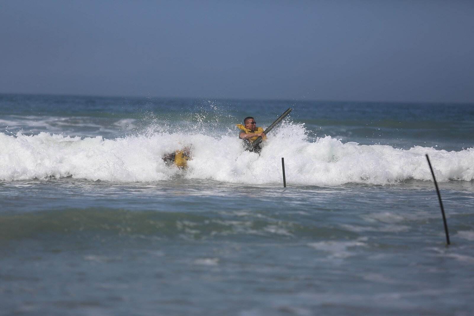 U.S. Marine Corps Cpl. Nelson Bernal and Sgt. Hyun Kim, bulk fuel specialists with Bulk Fuel Company, 7th Engineer Support Battalion, 1st Marine Logistics Group, hammer stakes into the ground to mark where the receiving hose will come in from off shore on Camp Pendleton, Calif., May 1, 2015. The receiving hose is used as part of the Beach Unloading System used to house fuel which is pumped from a ship off shore. (U.S. Marine Corps Photo by Cpl. Rodion Zabolotniy, Combat Camera/Released)