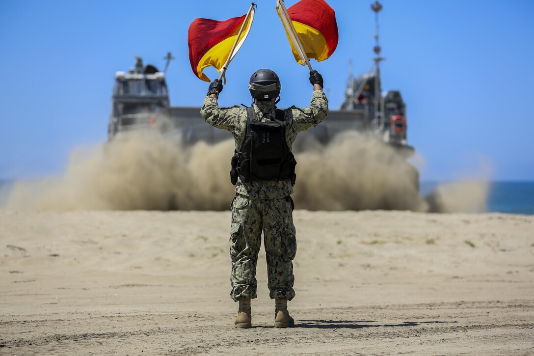U.S. Navy Landing Craft Air Cushioned (LCAC) vehicle from Assault Craft Unit 5 is guided off of Red Beach as part of a training exercise alongside Bulk Fuel Company, 7th Engineer Support Battalion aboard Camp Pendleton, Calif., April 27, 2015. This exercise reinforces the Marine Corps role as an amphibious force in readiness by maintaining capabilities through realistic training.(U.S. Marine Corps photo by Lance Cpl. Lauren Falk/Released)