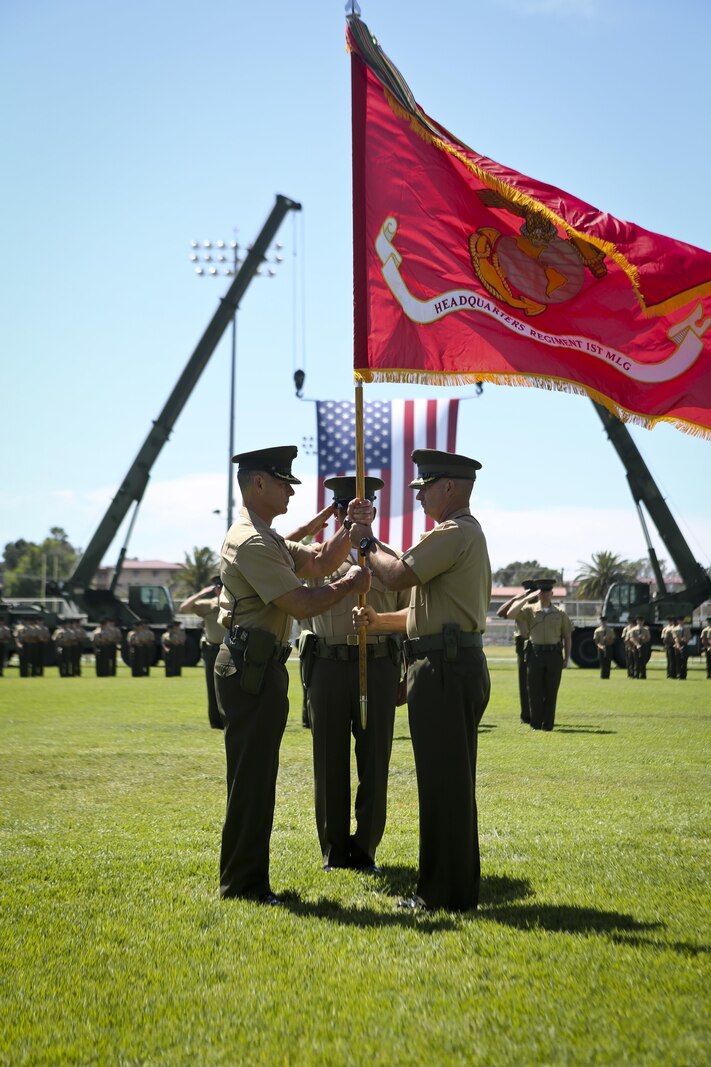 U.S. Marine Corps Col. Eric B. Kraft, off going commanding officer, Headquarters Regiment, 1st Marine Logistics Group, 1 Marine Expeditionary Force, passes the colors to on coming commanding officer Col. Phillip N. Frietze during the Change of Command Ceremony for Headquarters Regiment aboard Camp Pendleton Calif., May 1, 2015. The Change of Command Ceremony for Headquarters Regiment showcased the passing of command from Col. Eric B. Kraft to Col. Phillip N. Frietze. (U.S. Marine Corps photo by Lance Cpl. Lauren Falk/Released)