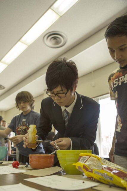 Students with Matthew C. Perry High School and Noda Gakuen High School make sacks during a visit to M.C. Perry aboard Marine Corps Air Station Iwakuni, Japan, April 24, 2015. The Visit is part of the Noda Gakuen High School’s Global International Course, thats main focus is to give students resources needed to improve language and communication skills, understand their roles in different societies and actively challenge themselves to try new things.