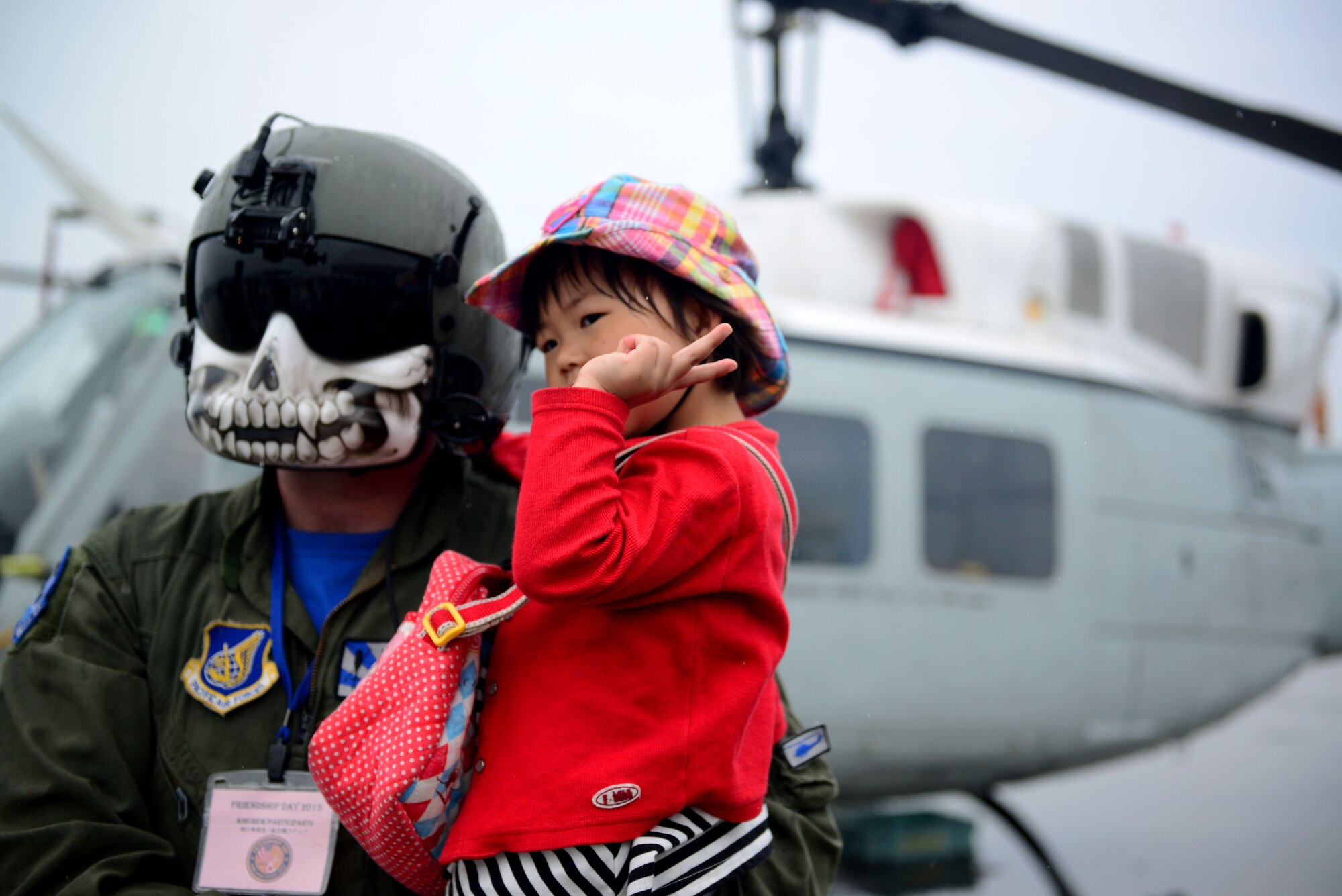Flight engineer Staff Sgt. Christopher Rector, 459th Airlift Squadron flight engineer, from Yokota Air Base, Japan, poses with a local girl during the first-ever joint Friendship Day Air Show hosted by Marine Corps Air Station Iwakuni, Japan and Japan Maritime Self-Defense Force at MCAS Iwakuni, Japan, May 3, 2015. The event allowed visitors the chance to see several aircraft demonstrations and to interact with Japanese and American service members. (U.S. Air Force photo by Tech Sgt. Melissa K. Mekpongsatorn/Released)

