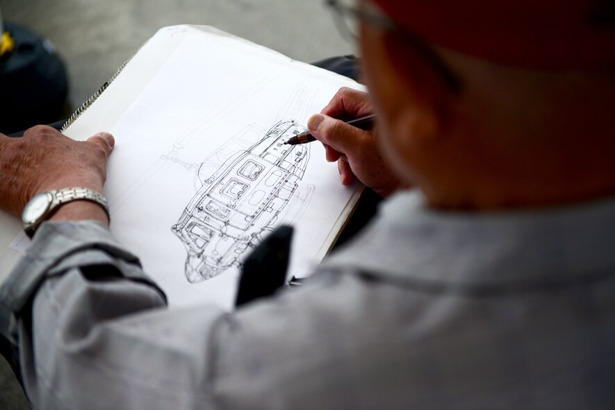 A man sketches a picture of the UH-1N Iroquois during Friendship Day 2015 at Marine Corps Air Station Iwakuni, Japan. MCAS and Japan Maritime Self-Defense Force hosted it's first-ever joint Friendship Day 2015 Air Show, May 3, 2015. Members with the 459th Airlift Squadron from Yokota Air Base, Japan, brought a UH-1N and a C-12 to the airshow to showcase their airlift capabilities to visitors. (U.S. Air Force photo by Tech Sgt. Melissa K. Mekpongsatorn/released)