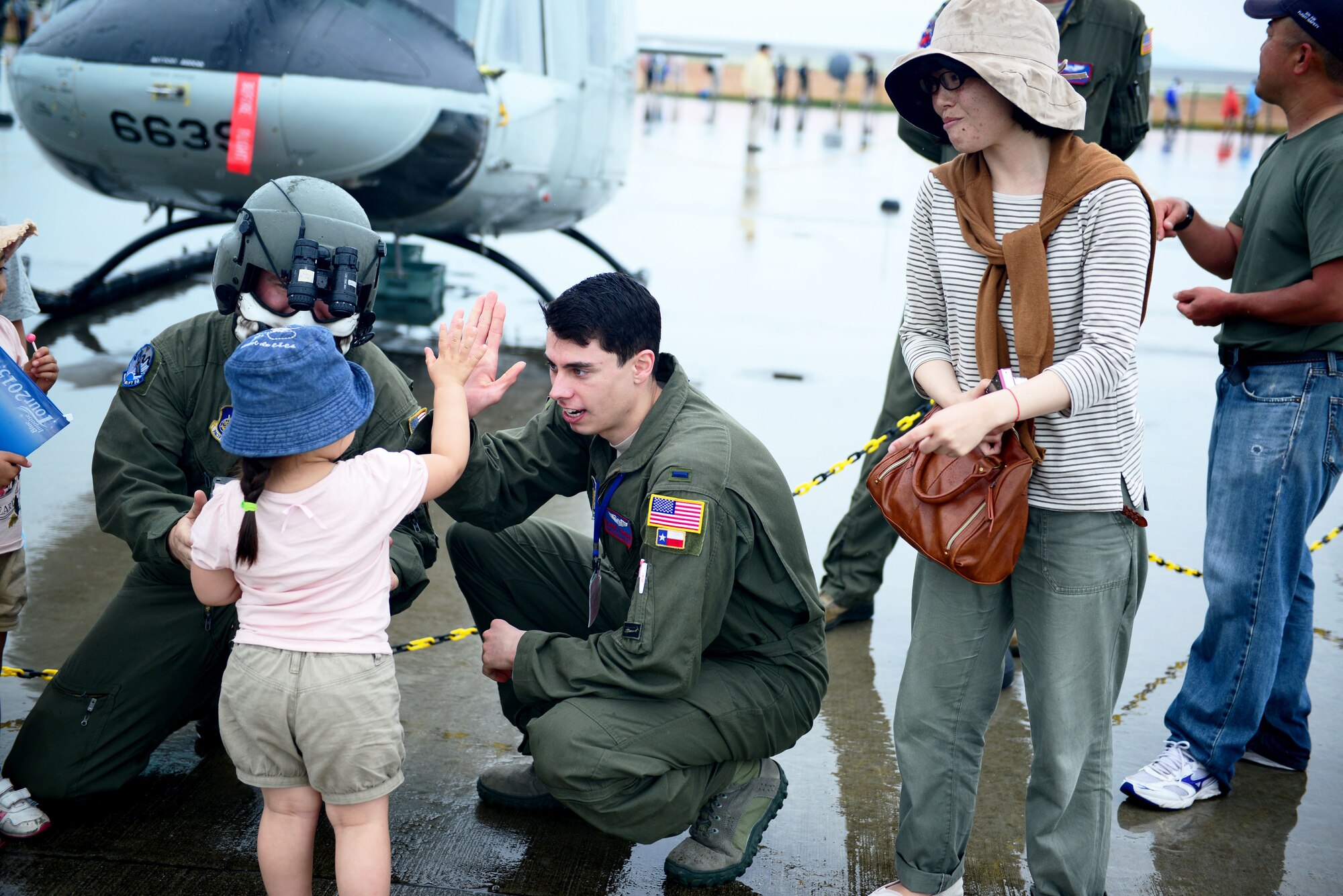 1st Lt. Daniel Trapani, 459th Airlift Squadron UH-1N pilot, high-fives a girl during Friendship Day 2015 Air Show, Marine Corps Air Station Iwakuni, Japan, and Japan Maritime Self-Defense Force hosted it's first-ever joint Friendship Day 2015 Air Show at MCAS Iwakuni, Japan, May 3, 2015. The event allowed visitors the chance to see several aircraft demonstrations and to interact with Japanese and American service members. (U.S. Air Force photo by Tech Sgt. Melissa K. Mekpongsatorn/Released)