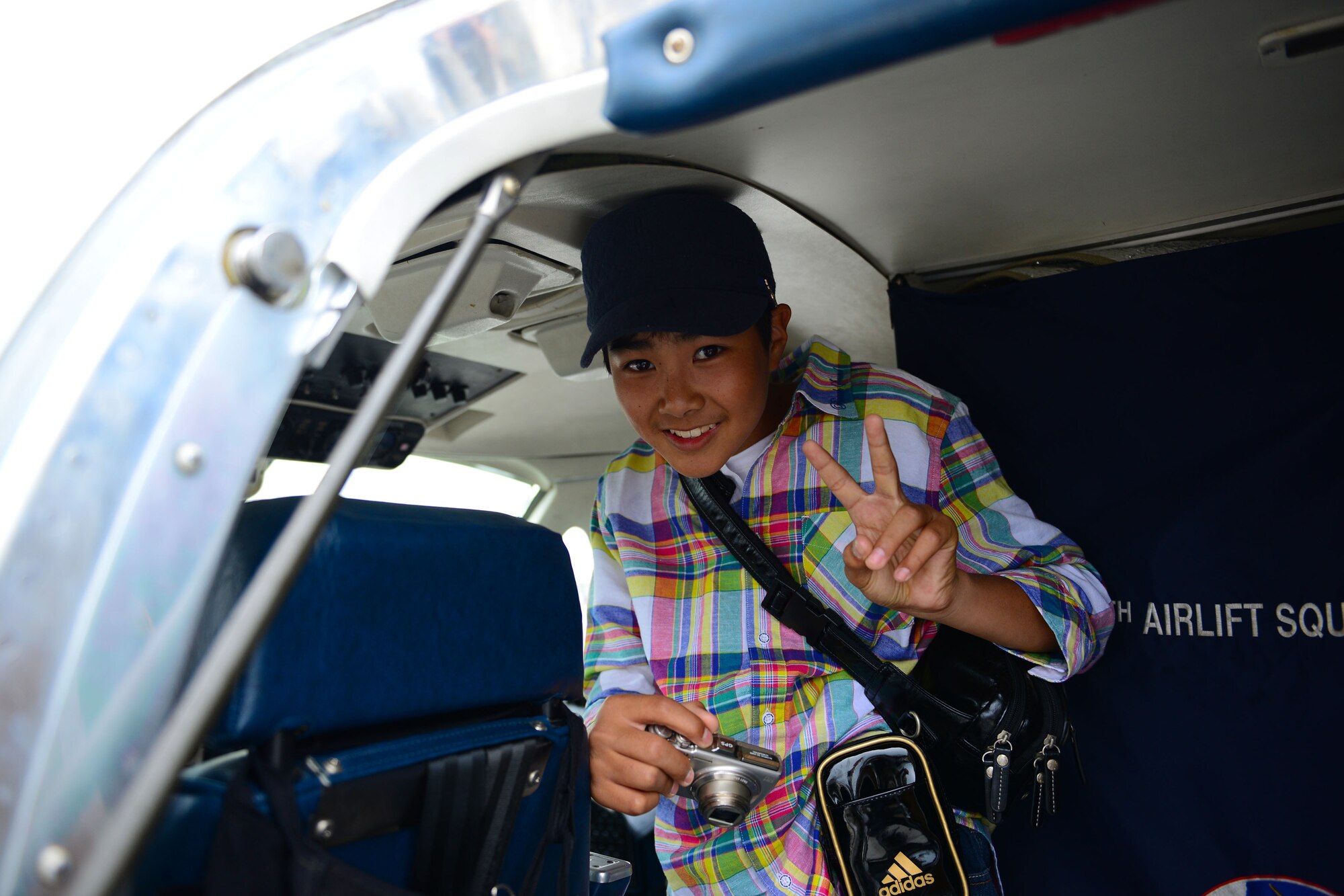 A local boy poses in the doorway of a C-12 Huron during the Japan Maritime Self-Defense Force/Marine Corps Air Station Iwakuni Friendship Day 2015 Air Show at MCAS Iwakuni, Japan, May 3, 2015. Members with the 459th Airlift Squadron from Yokota Air Base, Japan, brought a UH-1N and a C-12 to the airshow to showcase their airlift capabilities to visitors. (U.S. Air Force photo by Tech Sgt. Melissa K. Mekpongsatorn/Released)