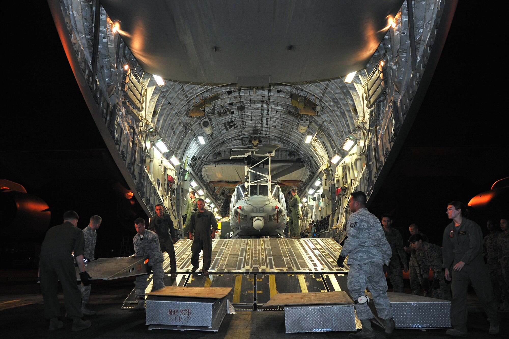 Airmen from the 36th Contingency Response Group and U.S. Marines to prepare to unload a U.S. Marine UH-1Y Huey helicopter from a U.S. Air Force C-17 Globemaster III, at Tribhuvan International Airport, May 5, 2015. The 36th CRG is a rapid-deployment unit designed to establish and maintain airfield operations in a forward operating location and joined U.S. Department of State and U.S. Agency for International Development led humanitarian assistance and disaster relief operations in support of the government and armed forces of Nepal. (U.S. Air Force photo by Staff Sgt. Melissa White/Released)