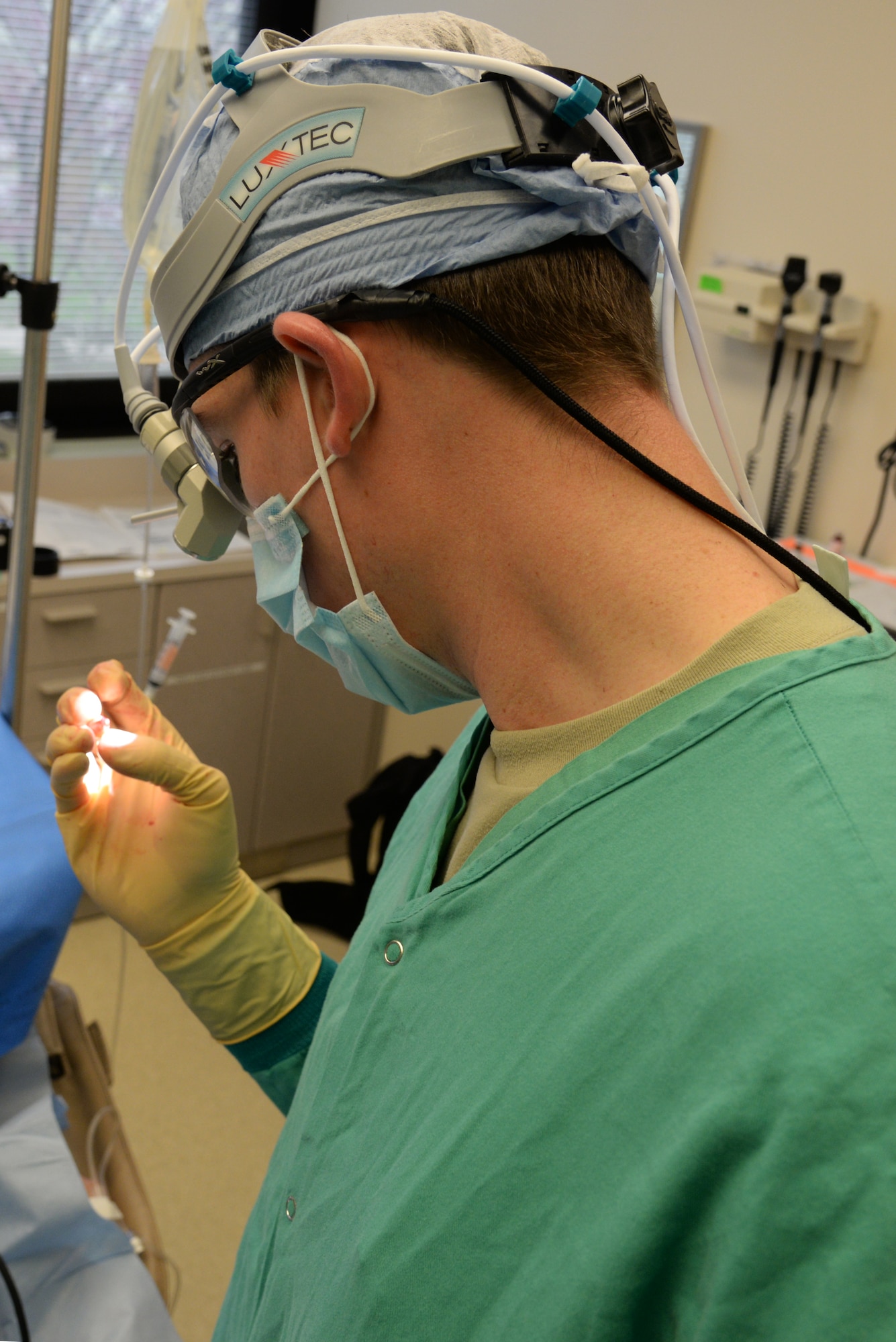 Capt. Kyle Christensen examines a tooth he extracted from a patient April 8, 2015, at the Scott Clinic, Scott Air Force Base, Illinois. Wisdom teeth are extracted to correct or prevent future problems that may occur. Christensen is a General Dentist from the 375th Dental Squadron. (U.S. Air Force Photo by Airman 1st Class Megan Friedl)
