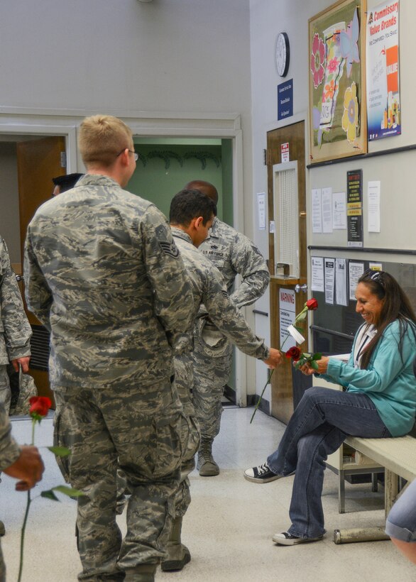 Araceli Martinez is presented red roses as part of an elaborate surprise coordinated by her husband, Tech. Sgt. Donald Martinez Jr., 31st Test and Evaluation Squadron, after coming home from his last deployment May 5. (U.S. Air Force photo by Rebecca Amber) 