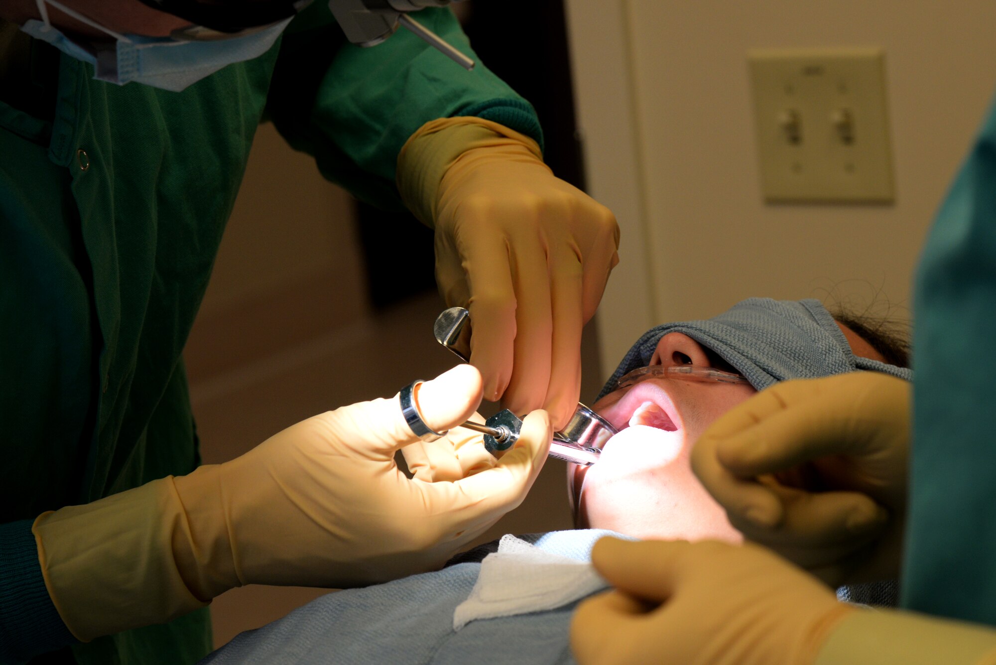 Capt. Kyle Christensen administers an anesthetic that will numb the area of where the tooth is being extracted April 8, 2015, at the Scott Clinic, Scott Air Force Base, Illinois. Wisdom teeth are extracted to correct or prevent future problems that may occur. Christensen is a General Dentist from the 375th Dental Squadron. (U.S. Air Force Photo by Airman 1st Class Megan Friedl)