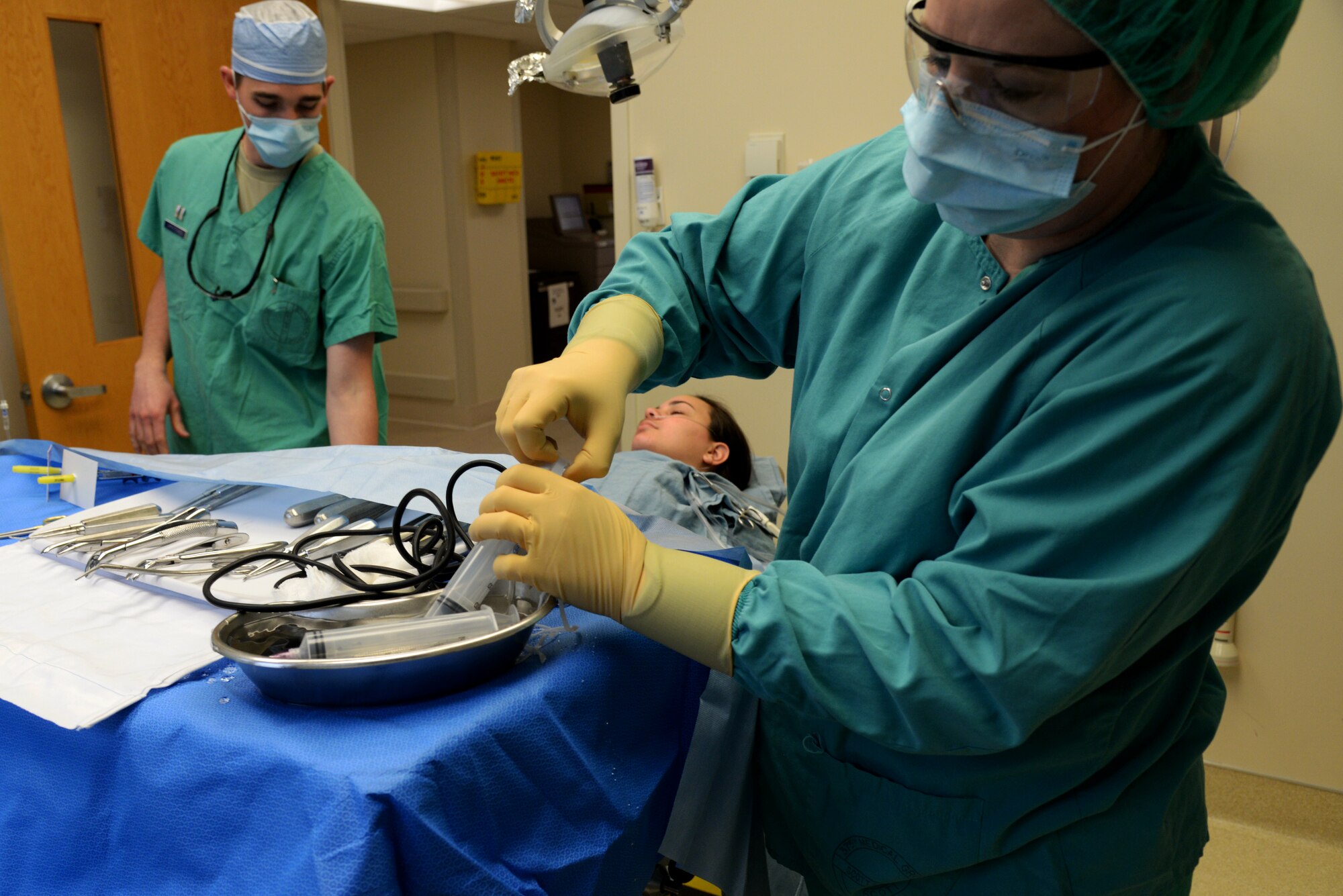 Capt. Kyle Christensen and Lisa Whisenhunt prepare for a wisdom teeth extraction April 8, 2015, at the Scott Clinic, Scott Air Force Base, Illinois. Wisdom teeth are extracted to correct or prevent future problems that may occur. Christensen is a General Dentist and Whisenhunt is a Dental Technician from the 375th Dental Squadron. (U.S. Air Force Photo by Airman 1st Class Megan Friedl)