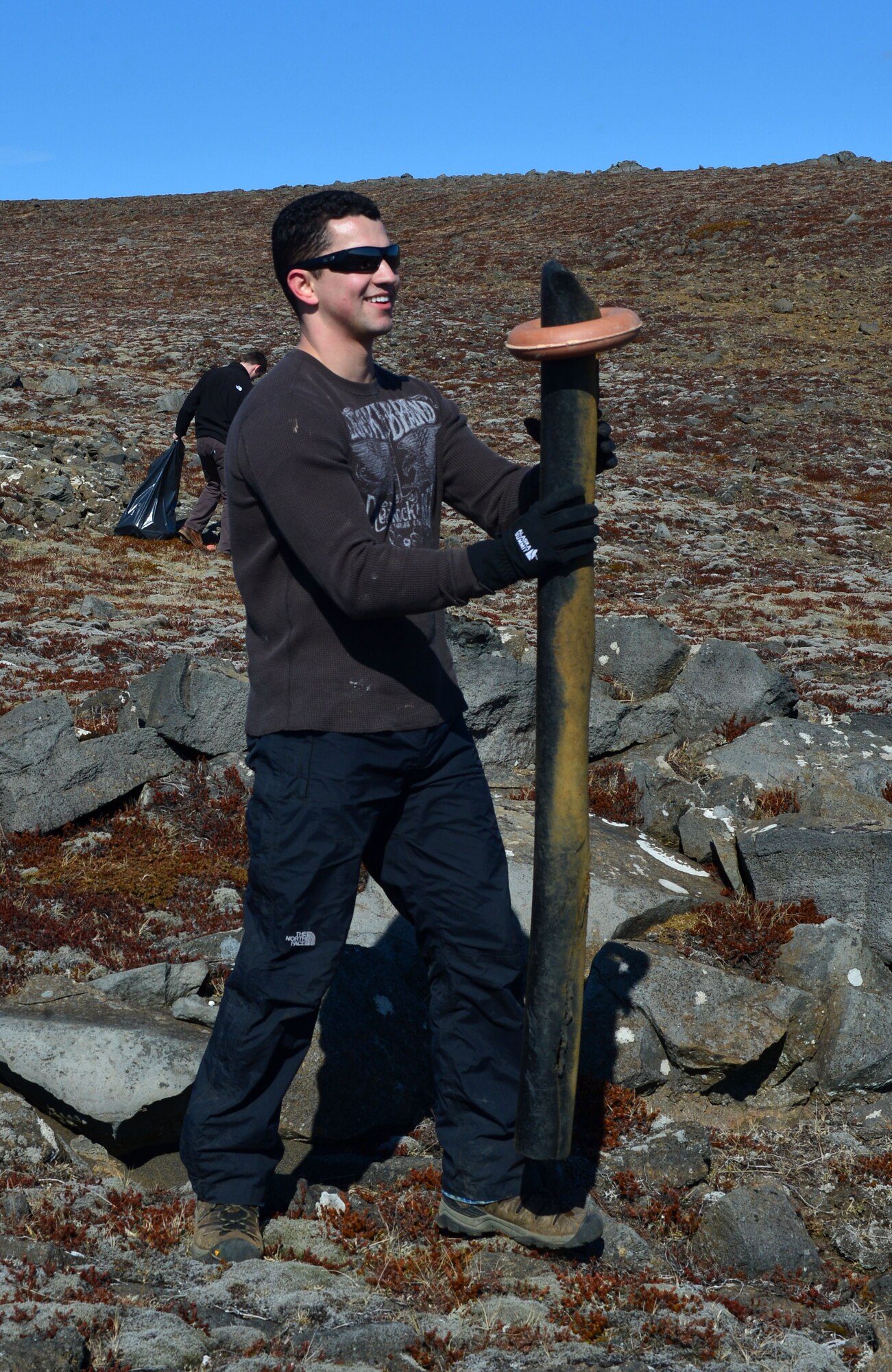 U.S. Air Force Staff Sgt. Isaiah Beltran of the 871st Air Expeditionary Squadron carries debris found during a beach clean-up on the Reykjanes Peninsula, Iceland, May 2, 2015. Airmen who deployed to Iceland for Icelandic Air Surveillance and Policing worked with members of the Blue Army, an Icelandic environmental organization, to clean up almost three tons of trash and debris along the coastline as a community service project. (U.S. Air Force photo by 2nd Lt Meredith Mulvihill/Released)