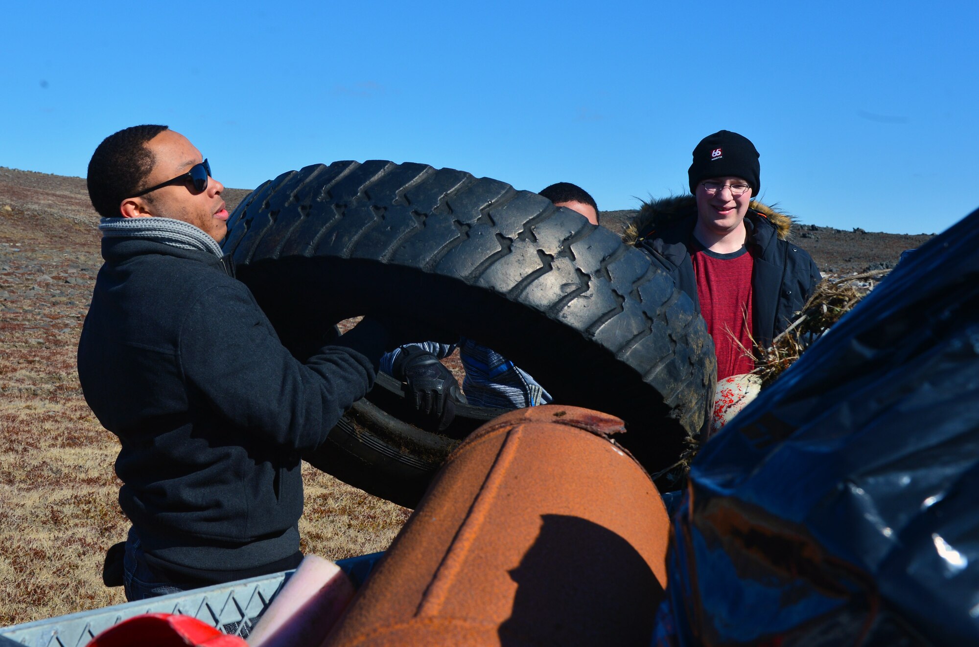 U.S. Air Force Staff Sgt. Cory Lewis and U.S. Air Force Airman 1st Class Derek Heldt of the 871st Air Expeditionary Squadron dispose of a tire found during a beach clean-up on the Reykjanes Peninsula, Iceland, May 2, 2015.Airmen who deployed to Iceland for Icelandic Air Surveillance and Policing worked with members of the Blue Army, an Icelandic environmental organization, to clean up almost three tons of trash and debris along the coastline as a community service project. (U.S. Air Force photo by 2nd Lt Meredith Mulvihill/Released)