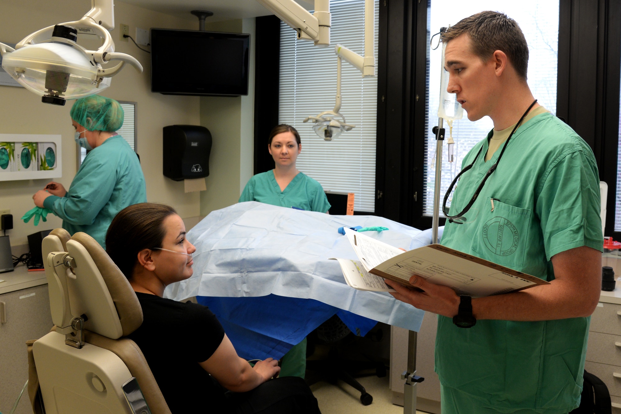 Capt. Kyle Christensen, 375th Dental Squadron General Dentist explains to a patient the wisdom teeth extraction procedure and the proper treatment she must do after the surgery April 8, 2015, at the Scott Clinic, Scott Air Force Base, Illinois. Wisdom teeth are extracted to correct or prevent future problems that may occur. (U.S. Air Force Photo by Airman 1st Class Megan Friedl)