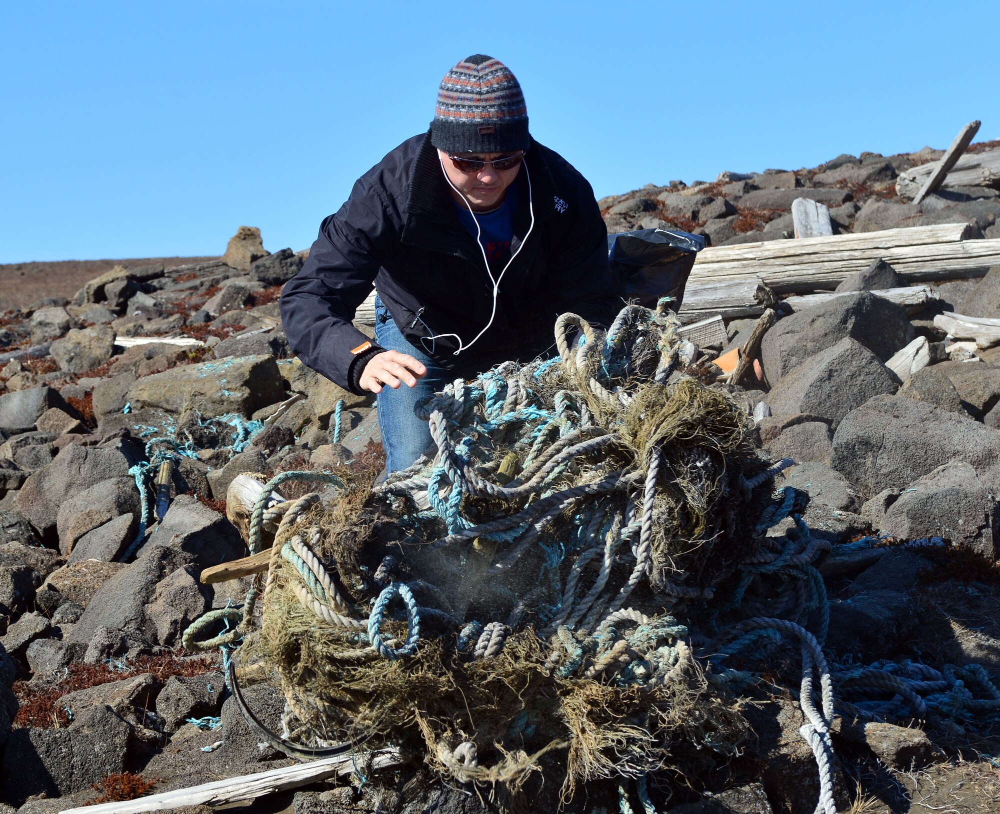 U.S. Air Force Master Sgt. Jason Lewis gathers rope found during a beach clean-up on the Reykjanes Peninsula, Iceland, May 2, 2015.Rope, buoys and other debris blown off boats made up a large portion of the trash Airmen deployed to Iceland for Icelandic Air Surveillance and Policing and members of the Blue Army, an Icelandic environmental organization, picked up along the coastline. (U.S. Air Force photo by 2nd Lt Meredith Mulvihill/Released)