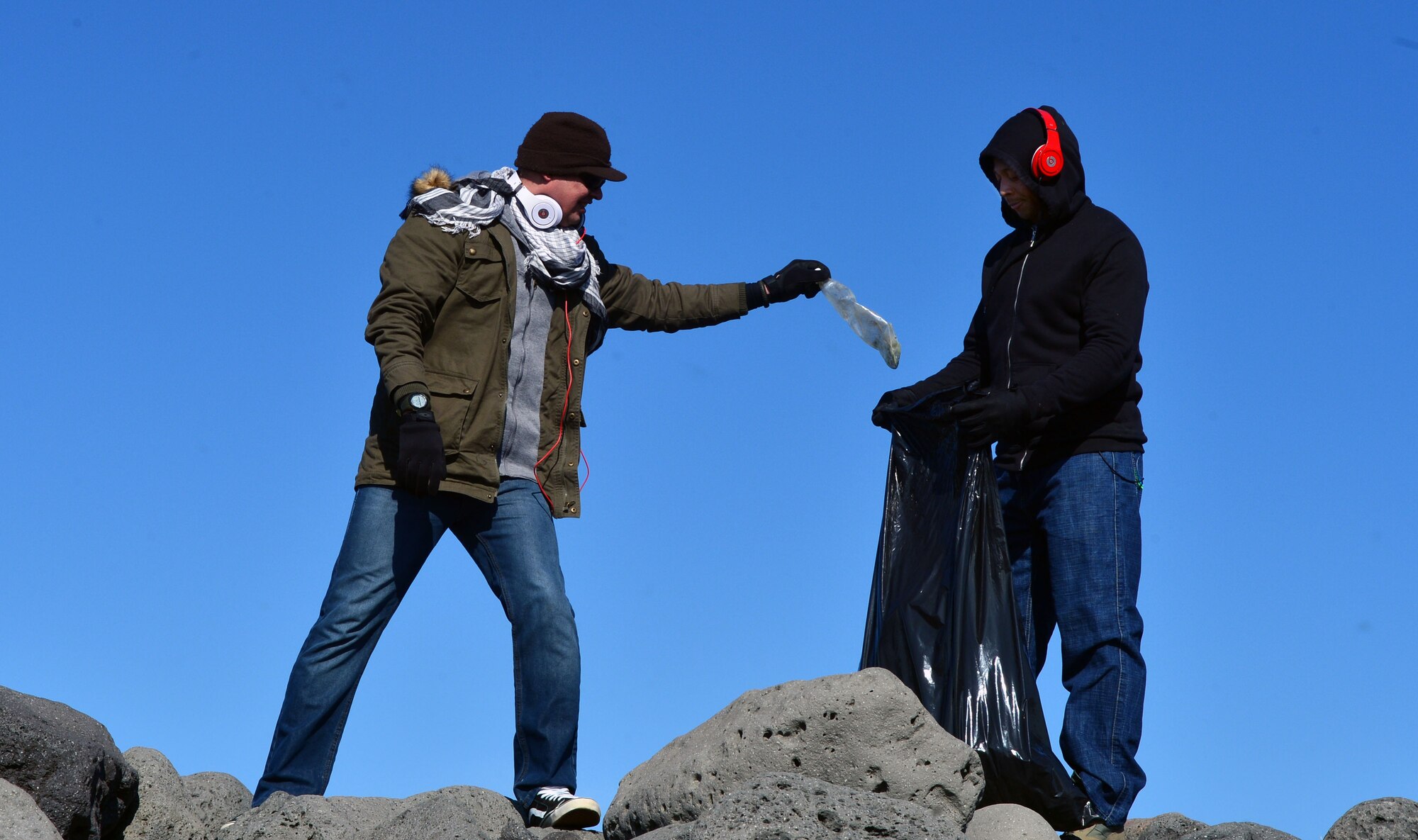 U.S. Air Force Master Sgt. Carlos Comas and U.S. Air Force Senior Airman Marvin Peabody of the 871st Air Expeditionary Squadron dispose of trash found during a beach clean-up on the Reykjanes Peninsula, Iceland, May 2, 2015."This was a really great opportunity to help the Icelandic people and show them some of the things we do outside our normal military operations," Comas said. (U.S. Air Force photo by 2nd Lt Meredith Mulvihill/Released)