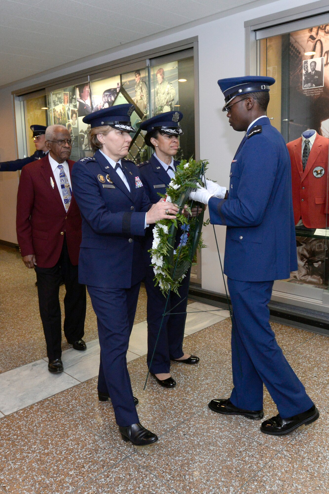 Tuskegee Airman ret. Lt. Col. James H. Harvey III, left, Academy Superintendent Lt. Gen. Michelle D. Johnson and Maj. Gen. Stayce Harris, commander of the 22nd Air Force, present a wreath to a cadet during a ceremony in Arnold Hall honoring the Tuskegee Airmen May 5, 2015. (U.S. Air Force Academy photo/Mike Kaplan)