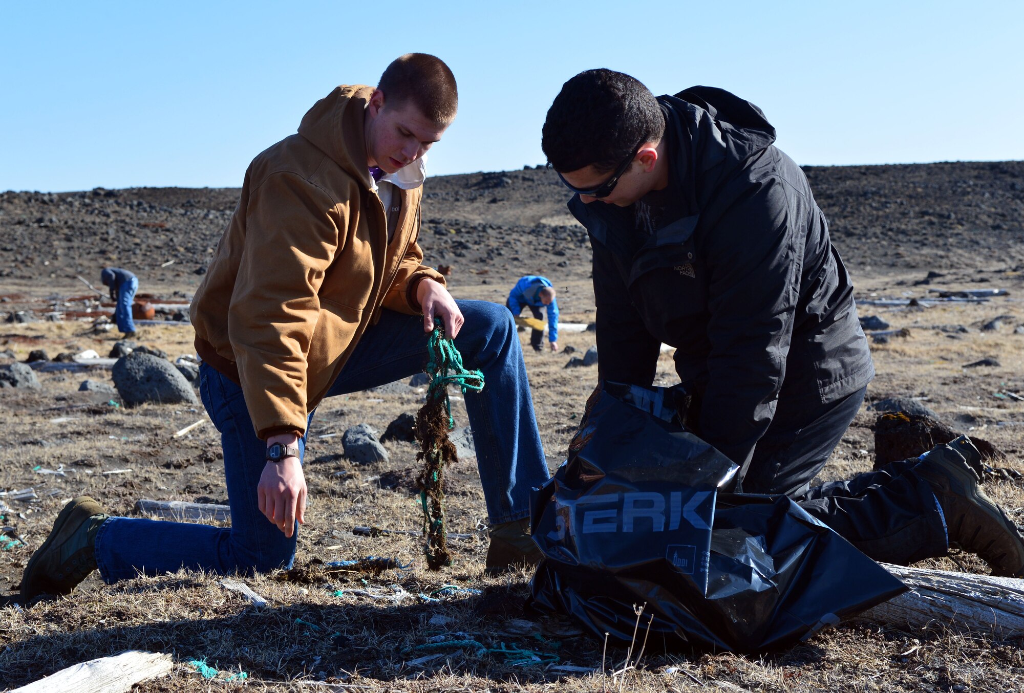 U.S. Air Force Airman 1st Class James Franklin and U.S. Air Force Staff Sgt. Isaiah Beltran of the 871st Air Expeditionary Squadron work together to pick up trash during a beach clean-up on the Reykjanes Peninsula, Iceland, May 2, 2015.Airmen who deployed to Iceland for Icelandic Air Surveillance and Policing worked with members of the Blue Army, an Icelandic environmental organization, to clean up almost three tons of trash and debris along the coastline as a community service project. (U.S. Air Force photo by 2nd Lt Meredith Mulvihill/Released)