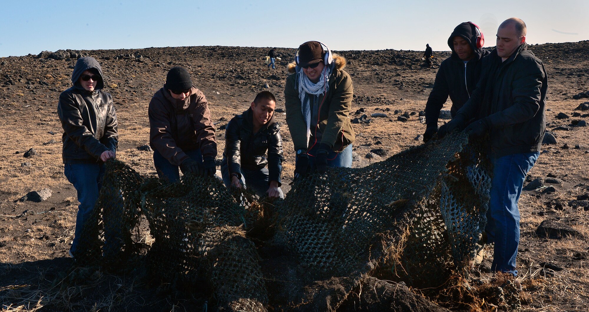U.S. Airmen from the 871st Air Expeditionary Squadron work to uncover a fishing net during a beach clean-up on the Reykjanes Peninsula, Iceland, May 2, 2015.Over 35 Airmen who deployed to Iceland for Icelandic Air Surveillance and Policing joined with members of Icelandic environmental organization the Blue Army to participate in the service project. (U.S. Air Force photo by 2nd Lt Meredith Mulvihill/Released)