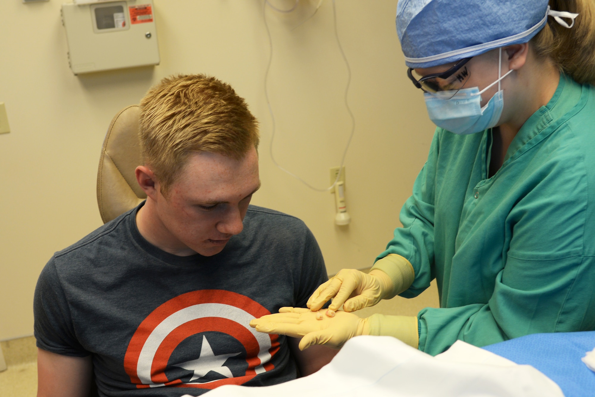 Maegan Wallinger shows a patient the four wisdom teeth that were extracted during a procedrue at the 375th Medical Group Clinic at Scott Air Force Base, Illinois, April 29, 2015. Wisdom teeth are removied to correct or prevent future problems that may occur. Wallinger is a dental assistant from the 375th DS. (U.S. Air Force Photo by Airman 1st Class Megan Friedl)