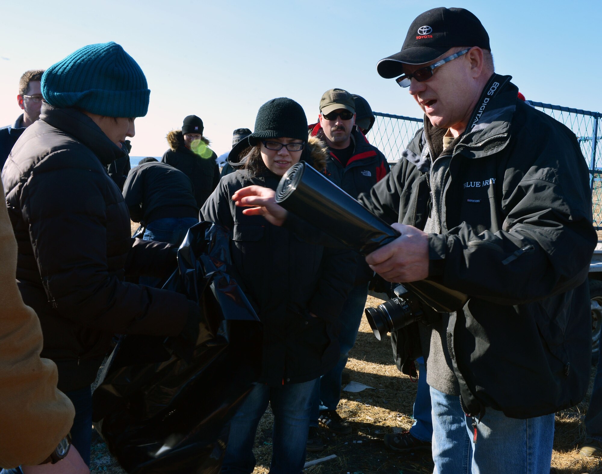 Tómas Knútsson, leader of the Blue Army, hands trash bags out to U.S. Airmen from the 871st Air Expeditionary Squadron during a beach clean-up on the Reykjanes Peninsula, Iceland, May 2, 2015. Airmenwho deployed to Iceland for Icelandic Air Surveillance and Policing worked with members of the Blue Army, an Icelandic environmental organization, to clean up almost three tons of trash and debris along the coastline as a community service project. (U.S. Air Force photo by 2nd Lt Meredith Mulvihill/Released)