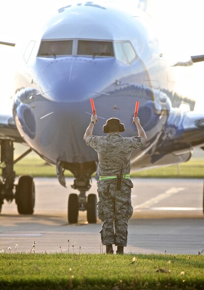 Master Sgt. Brian Fark, a 932nd Airlift Wing Maintenance Group designated crew chief, guides a C-40 back from its parking spot early in the morning as the aircraft prepares for take off April 30, 2015, Scott Air Force Base Ill. The 932nd AW is an Air Force Reserve flying unit that flies the C-40C, an operation support and team travel aircraft. (U.S. Air Force photo / Tech. Sgt. Christopher Parr)