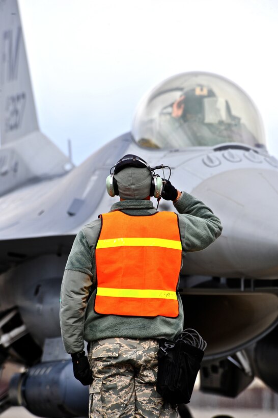A U.S. Air Force crew chief assigned to the 93rd Fighter Squadron, Homestead Air Reserve Base, Fla., salutes his pilot May 5, 2015, prior to take off during RED FLAG-Alaska (RF-A) 15-2 at Eielson Air Force Base, Alaska. RF-A is a Pacific Air Forces-directed field training exercise for U.S. and allied forces to train in simulated air-combat situations. (U.S. Air Force photo by Tech. Sgt. Miguel Lara III/Released)