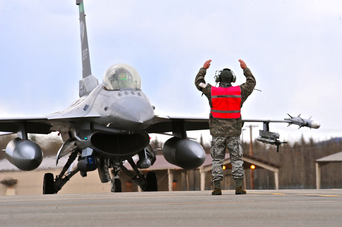 A U.S. Air Force crew chief assigned to the 112th Fighter Squadron, Toledo Air National Guard Base, Ohio, communicates instructions to his pilot May 5, 2015, during RED FLAG-Alaska (RF-A) 15-2, at Eielson Air Force Base, Alaska.  The work completed by crew chiefs provides mission-capable aircraft for pilots so they can provide air support, serving a vital role in the overall RF-A mission. (U.S. Air Force photo by Tech. Sgt. Miguel Lara III/Released)